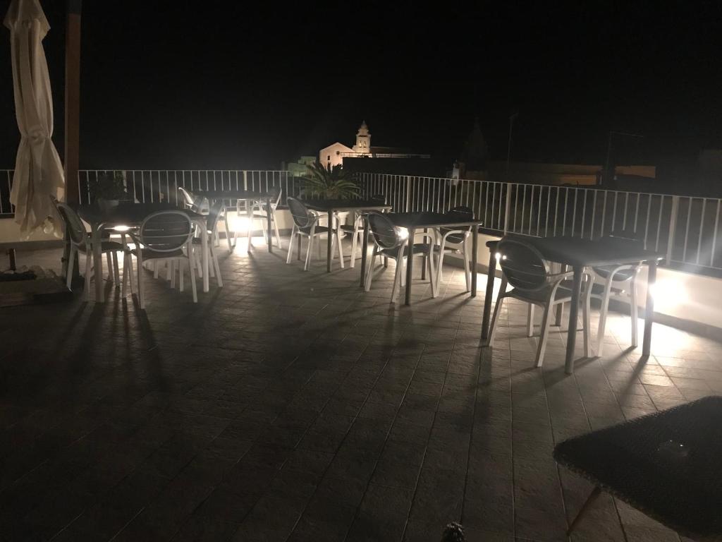 a group of tables and chairs on a patio at night at Estlevante B&B in Vieste
