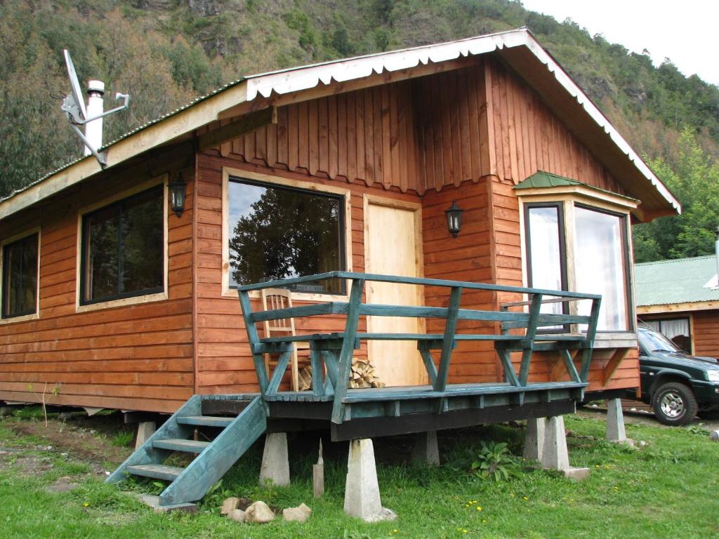 eine kleine Holzhütte mit einer Veranda und einem Balkon in der Unterkunft Parque Ilihue in Lago Ranco