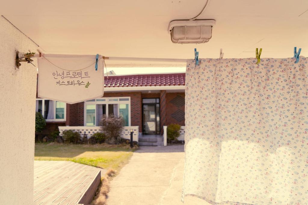a house with a curtain in front of a yard at Hello Project Guesthouse in Jeju