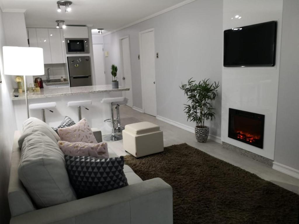 a living room with a couch and a fireplace at CPM Apartment in Viña del Mar