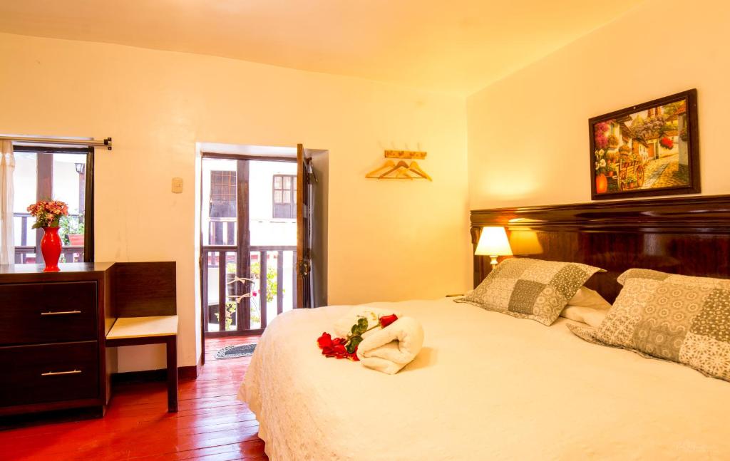 Un dormitorio con una cama con una flor. en Gringo Bill's Cusco, en Cusco