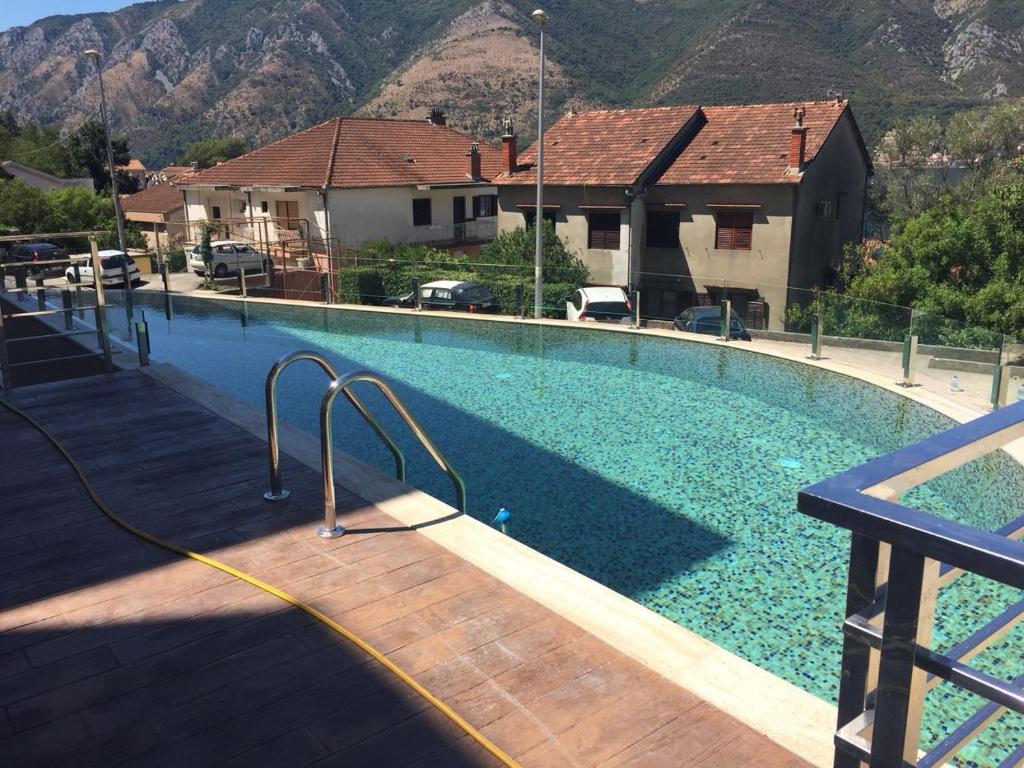 a large swimming pool in a house with mountains at Minka in Kotor