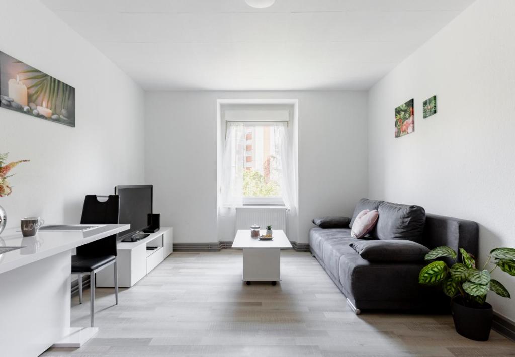 ein Wohnzimmer mit einem Sofa und einem Tisch in der Unterkunft Comfort Stay Basel Airport 1B46 in Saint-Louis