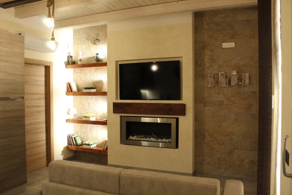 デセンツァーノ・デル・ガルダにあるVilla Martinaのリビングルーム(テレビ、暖炉付)