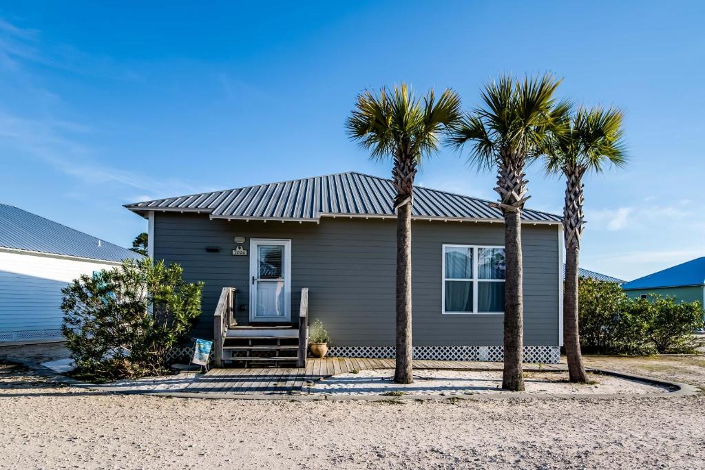 a gray house with palm trees in front of it at The Rookery III Unit 7024 Cottage in Gulf Shores