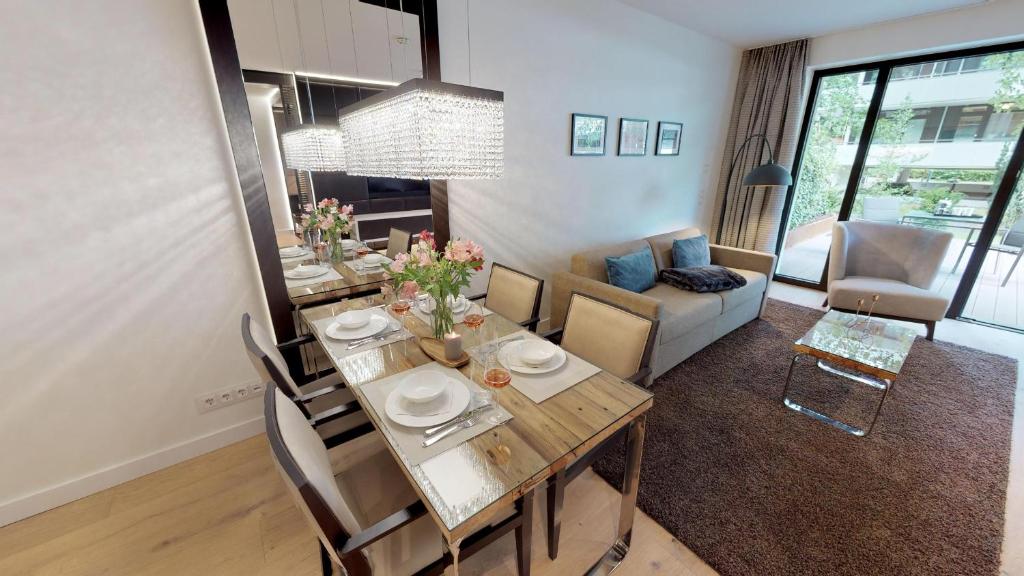 una sala da pranzo e un soggiorno con tavolo e sedie. di White Pearl Apartment 0.11 a Timmendorfer Strand