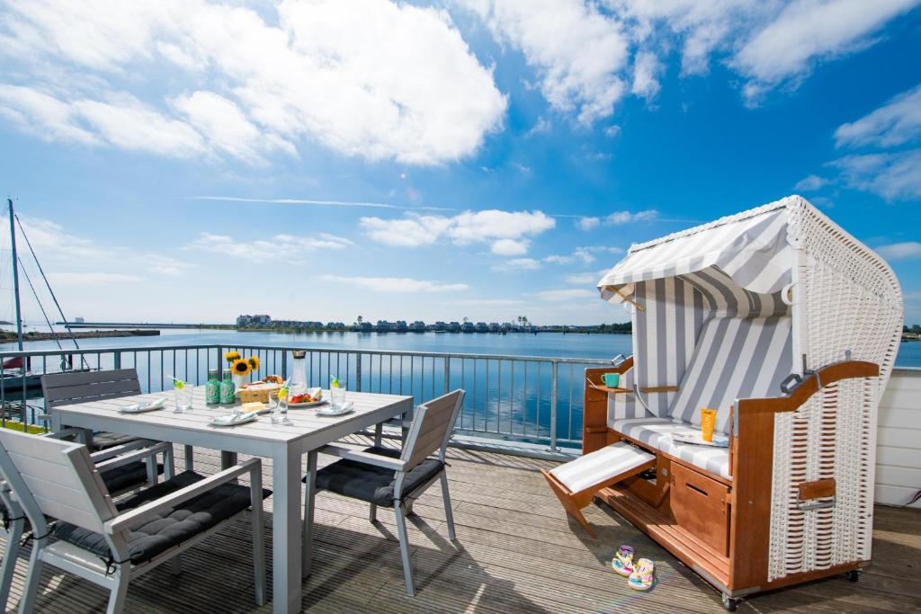 a table and chairs on a deck with a view of the water at Waterkant in Olpenitz