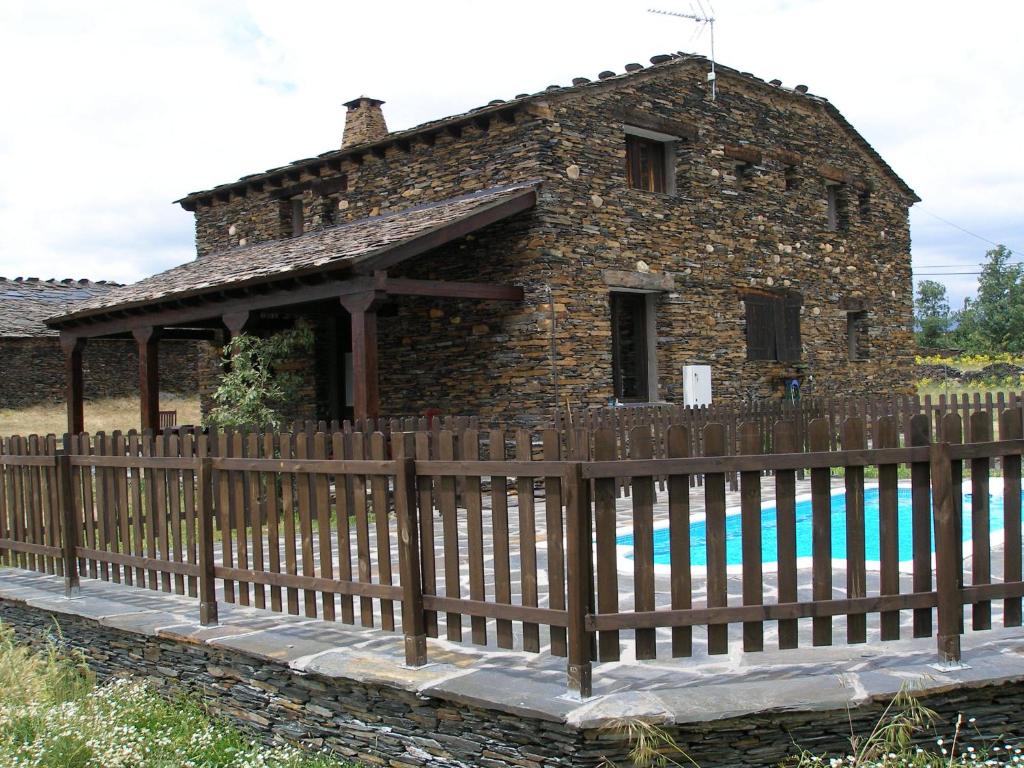 a house with a wooden fence in front of it at La Pizarra Negra in Campillejo