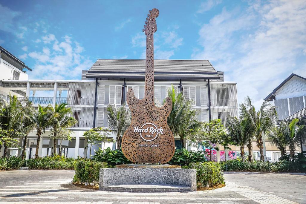 Hard Rock Hotel Desaru Coast في دِسارو: تمثال زرافة كبير امام مبنى