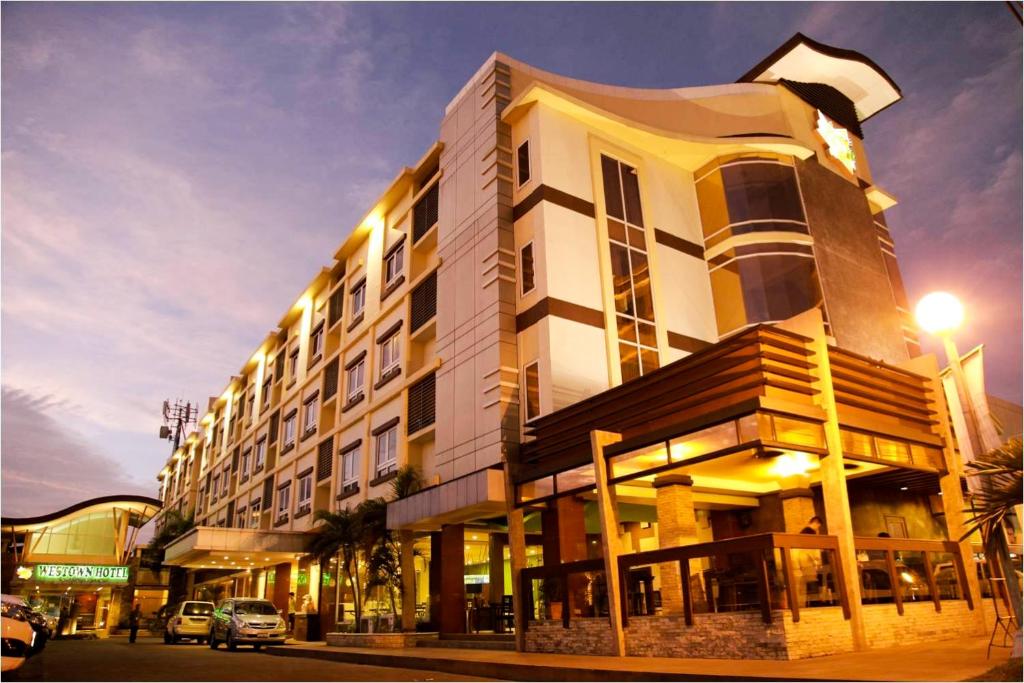 un gran edificio en una calle de la ciudad con un semáforo en MO2 Westown Hotel Iloilo, en Iloilo City