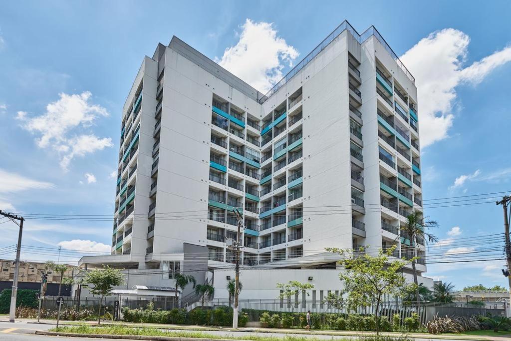 a large white building with windows on a street at Studio Wise Anhembi in São Paulo