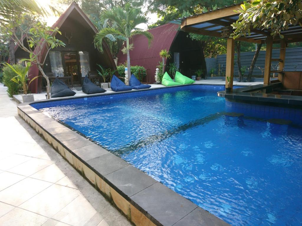 a large blue swimming pool with blue water at Coral Beach 2 Bungalow in Gili Trawangan