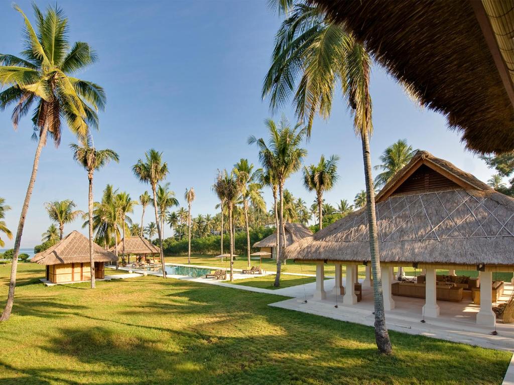 a resort with palm trees and a swimming pool at Villa Sepoi Sepoi by Elite Havens in Tanjung