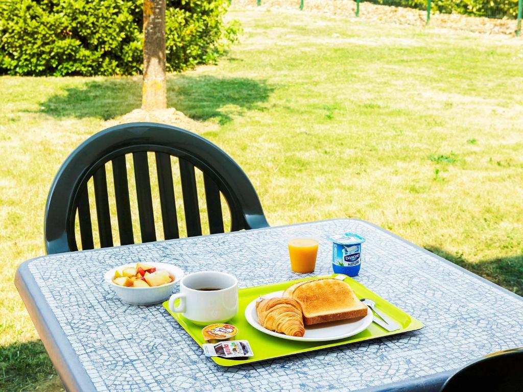 a table with a plate of breakfast food on it at ibis budget Chartres in Chartres