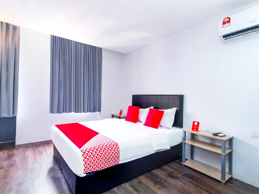 1 dormitorio con 1 cama grande con almohadas rojas en Super OYO 251 Intime Hotel en Kuala Lumpur