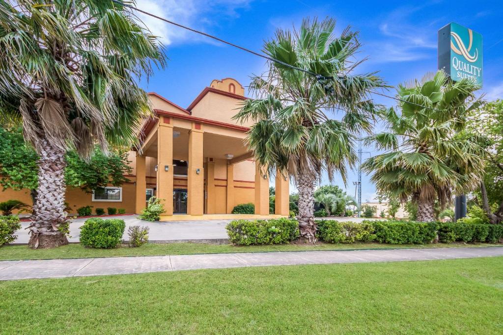 un edificio con palmeras delante en Quality Suites en San Antonio