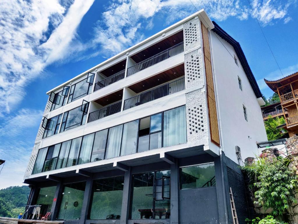 a white building with large windows on the side of it at Whispering Mountains Boutique Hotel in Zhangjiajie