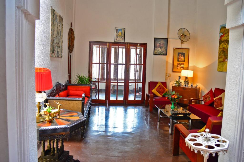 a living room with couches and tables in a room at Kandy Inn Madugalle’s family guest house in Kandy