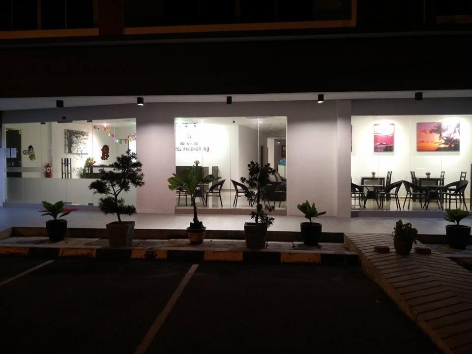 a room with potted plants in front of a building at Hotel Pangkor SJ in Pangkor