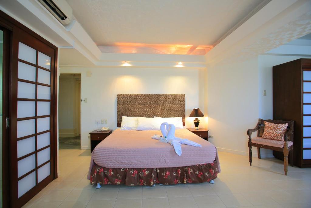 un dormitorio con una cama con un animal de peluche en Wild Orchid Beach Resort, en Olóngapo
