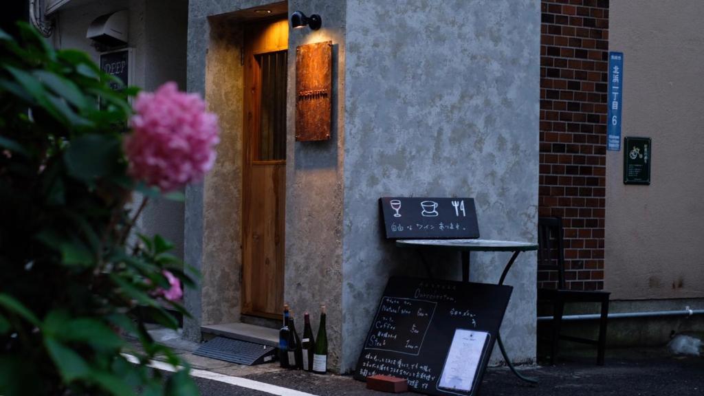 un edificio con una señal delante de una puerta en Beppu hostel&cafe ourschestra, en Beppu