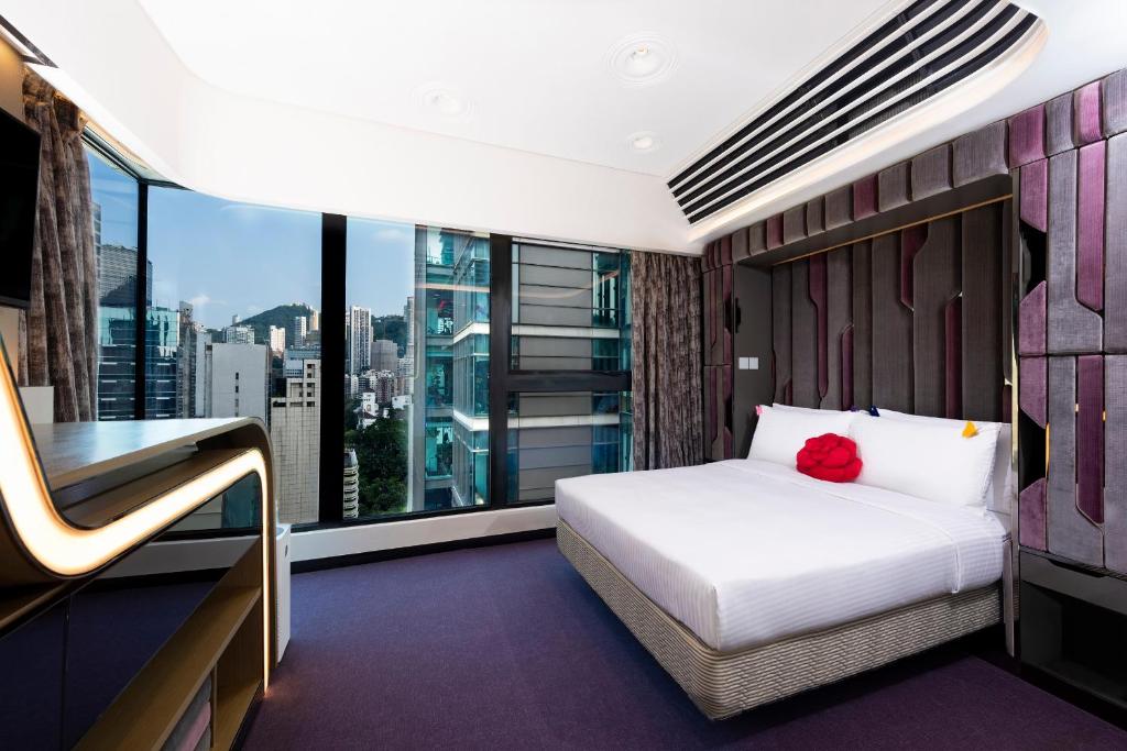 Butterfly on LKF Boutique Hotel Central في هونغ كونغ: غرفة فندقية بسرير ونافذة كبيرة