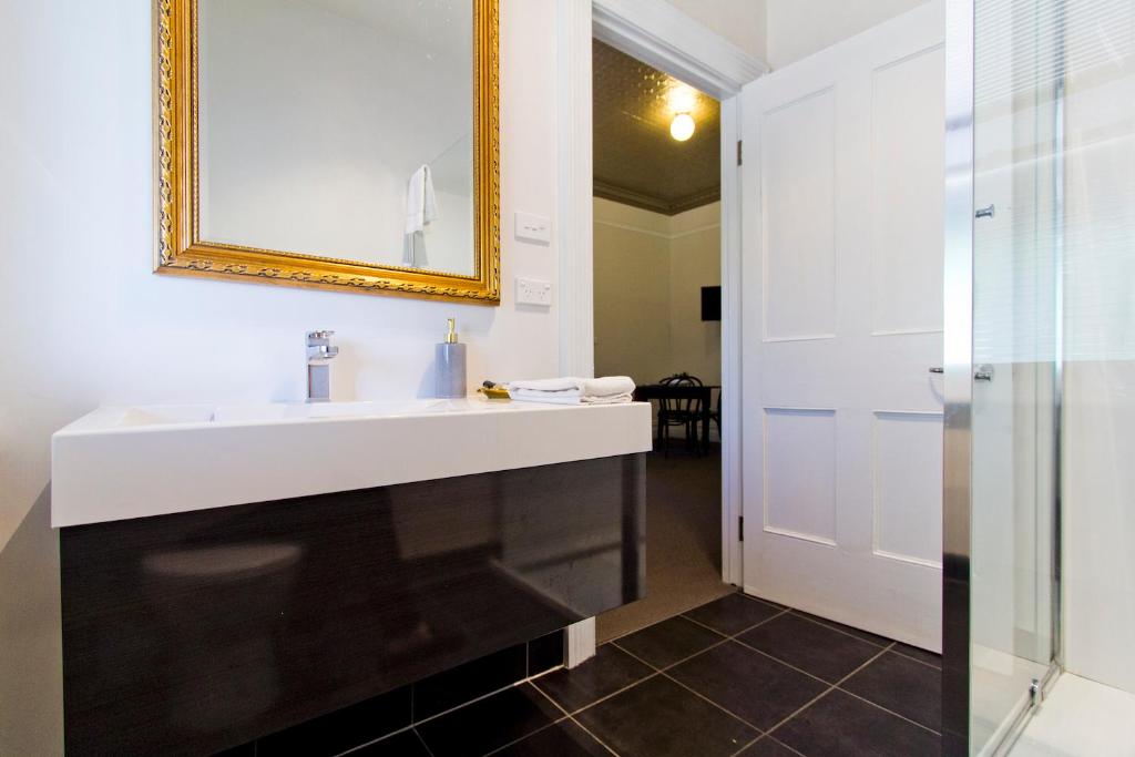 a bathroom with a white sink and a mirror at Deloraine Hotel in Deloraine