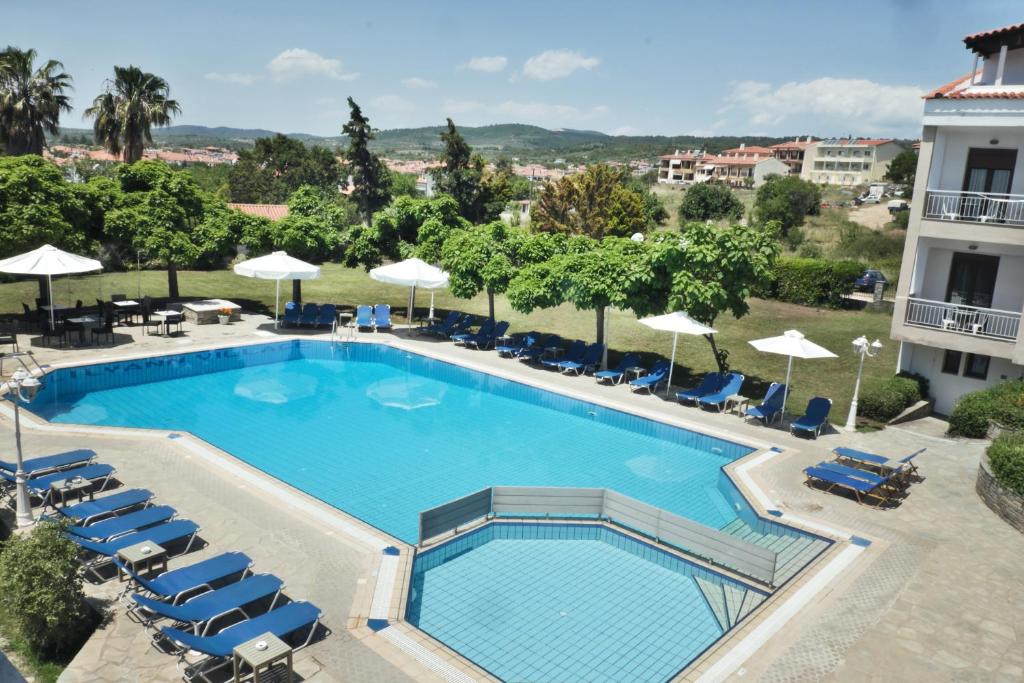 a large swimming pool with chairs and umbrellas at Acrotel Lily Ann Village in Nikiti