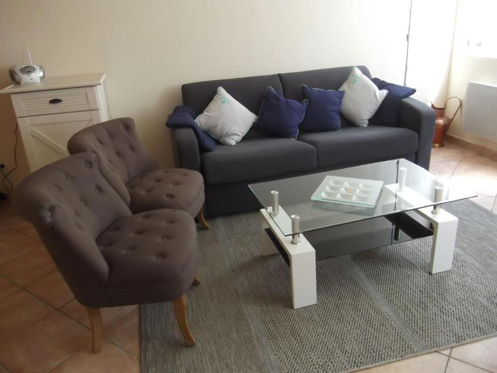 ein Wohnzimmer mit einem Sofa, einem Tisch und einem Stuhl in der Unterkunft JOLIE MAISON ANCIENNE RENOVEE PRES DU ZOO BEAUVAL TOUT CONFORT in Selles-sur-Cher