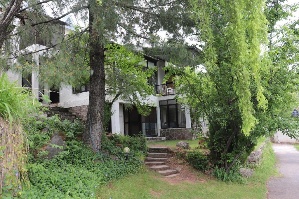 una casa con árboles y escaleras delante en Bhurban Valley Cottages 2, en Bhurban