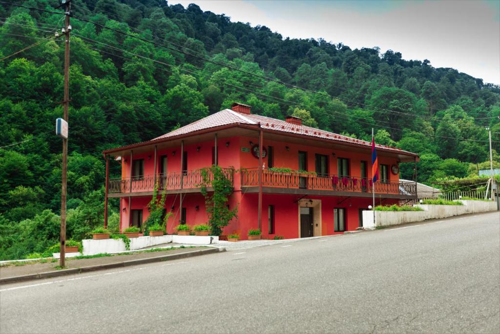 um edifício vermelho na berma de uma estrada em Ariana Family Hotel em Dilijan