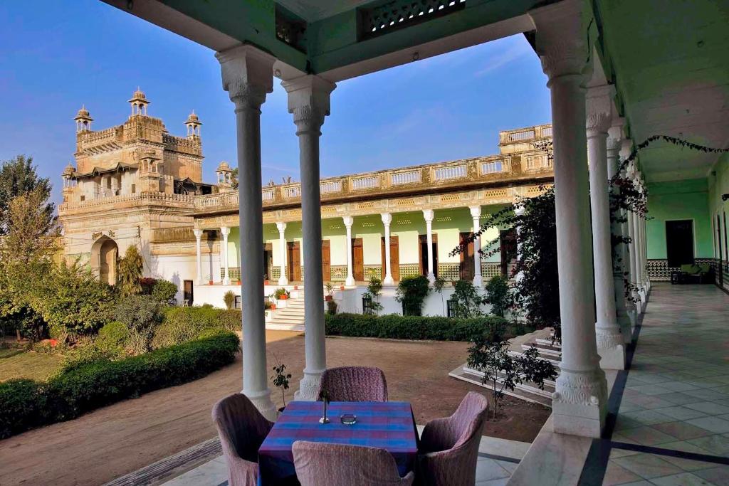 a building with a table and chairs in front of it at Neemrana's - Piramal Haveli in Bagar