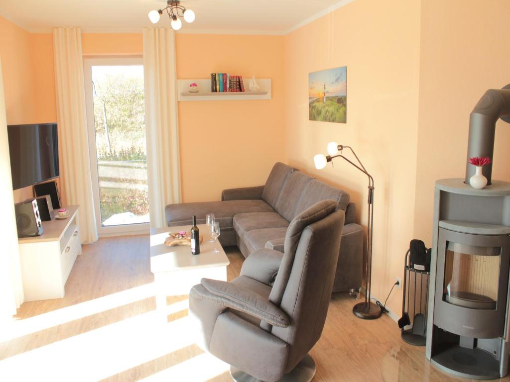 a living room with a couch and a tv at Strandläufer im Kirschgarten in Kellenhusen