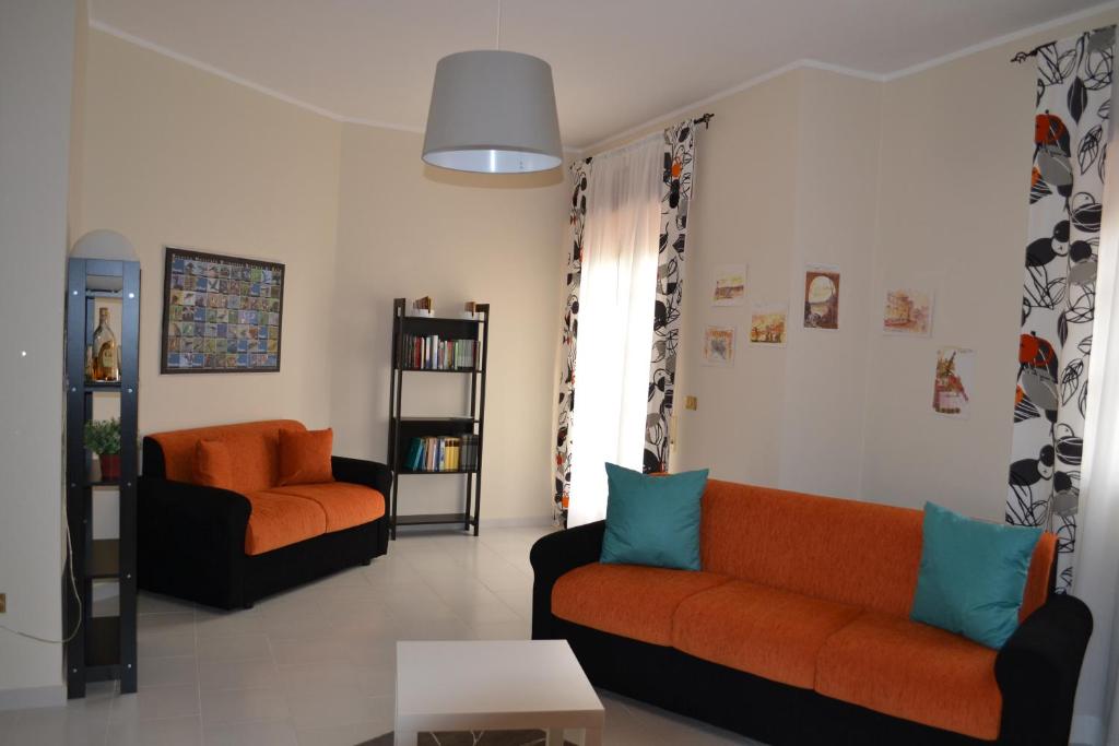 a living room with two couches and a table at Bed & Breakfast 21 in Gela