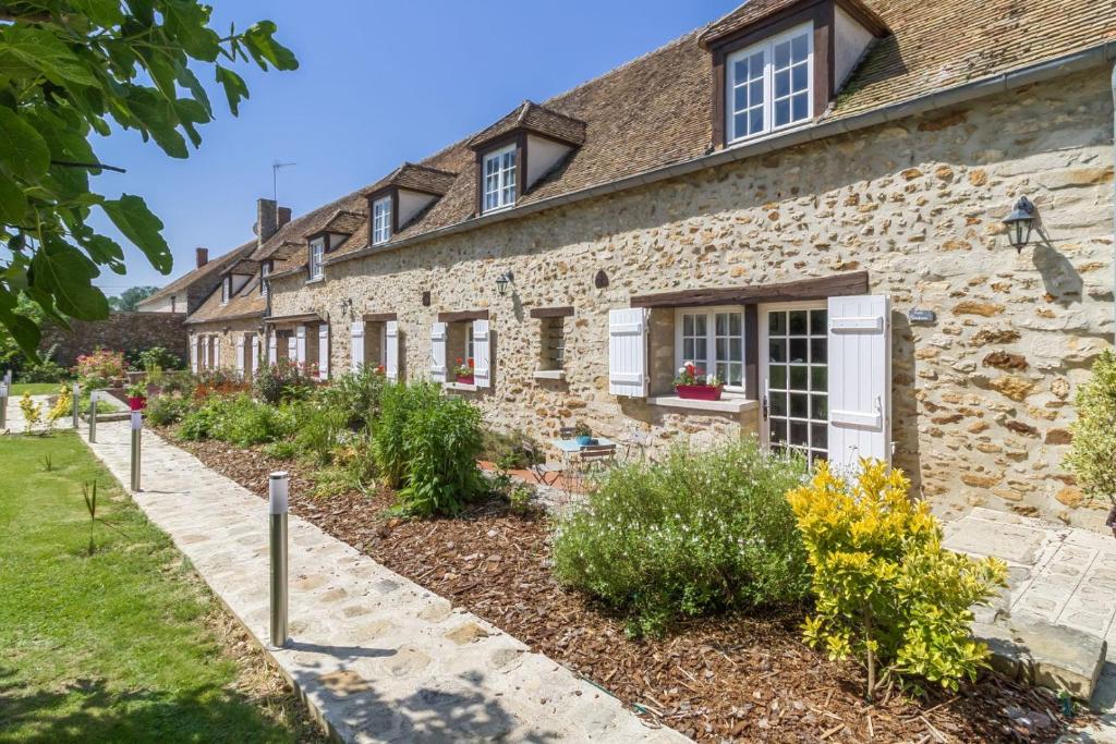 a stone house with a garden in front of it at Domaine des Trois chateaux in Moisenay