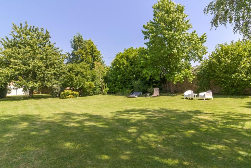 a park with chairs and trees in a field at Suite Cupidon- Domaine des trois châteaux in Moisenay