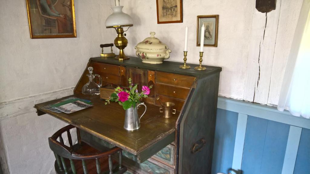 an old wooden desk with a vase of flowers on it at Thurup Hus in Assens