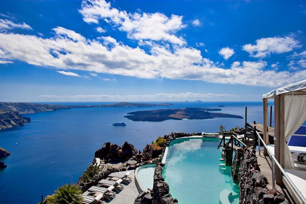 a swimming pool with a view of the water at Honeymoon Petra Villas in Imerovigli