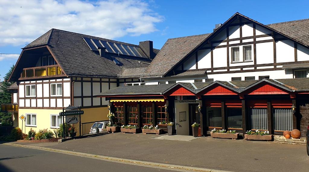 ein großes schwarzweißes Gebäude mit vielen Fenstern in der Unterkunft Landgasthof Groh in Ulrichstein