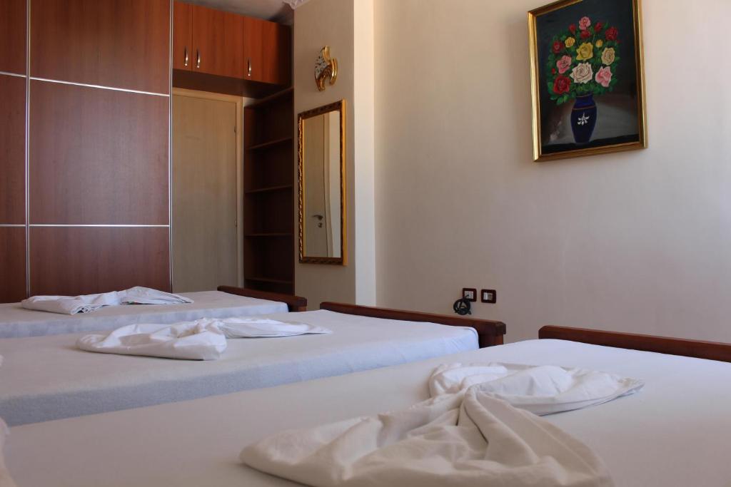 due letti in una camera d'albergo con asciugamani sopra di Amal Vlora Apartament a Vlorë