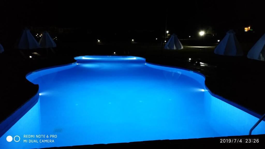 a blue lighted swimming pool at night at Roxane in Hanioti