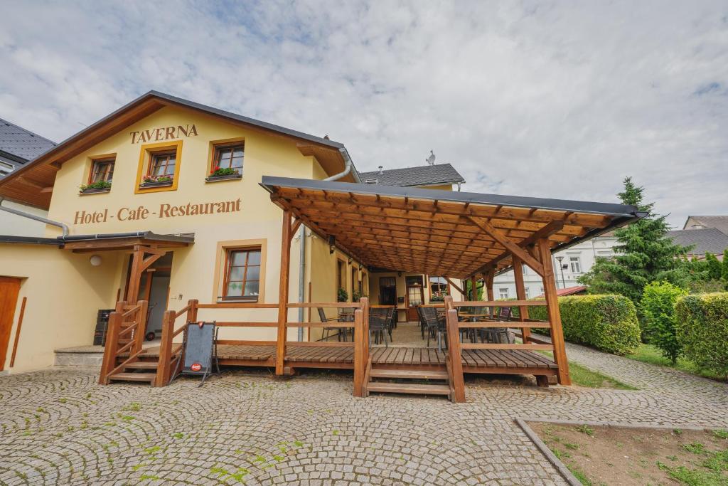 ein großes Gebäude mit einer großen Holzpergola in der Unterkunft Hotel Taverna in Javorník