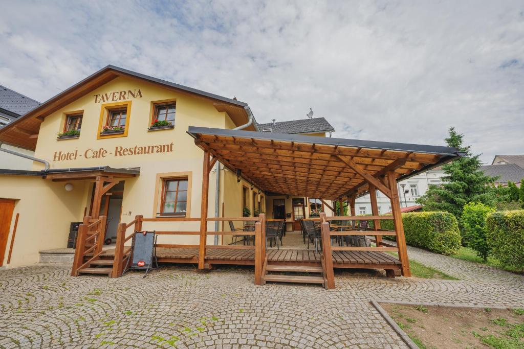 a large building with a large wooden pergola at Hotel Taverna in Javorník