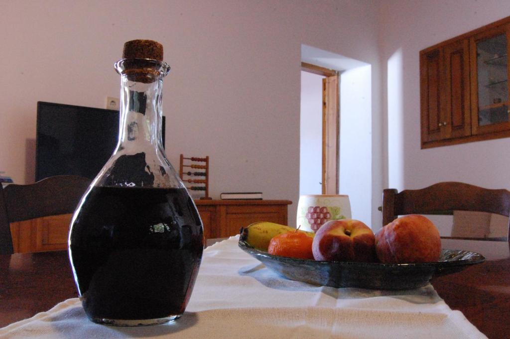 una botella de refresco sentada en una mesa con un bol de fruta en Old Winery House en Kolymvari