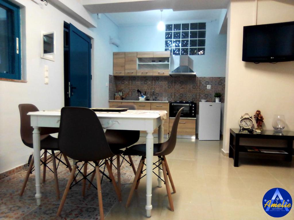 a kitchen with a table and chairs in a room at Amelie Apartment in Preveza