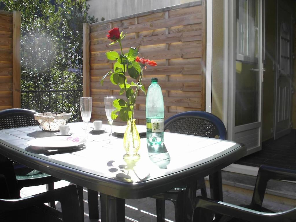 einen Tisch mit einer Vase mit einer Blume darin in der Unterkunft Appartement Côté Terrasse in Vals-les-Bains
