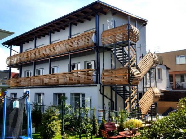 - un bâtiment avec des balcons en bois sur le côté dans l'établissement Róża Wiatrów Dom Wypoczynkowy, à Kołobrzeg