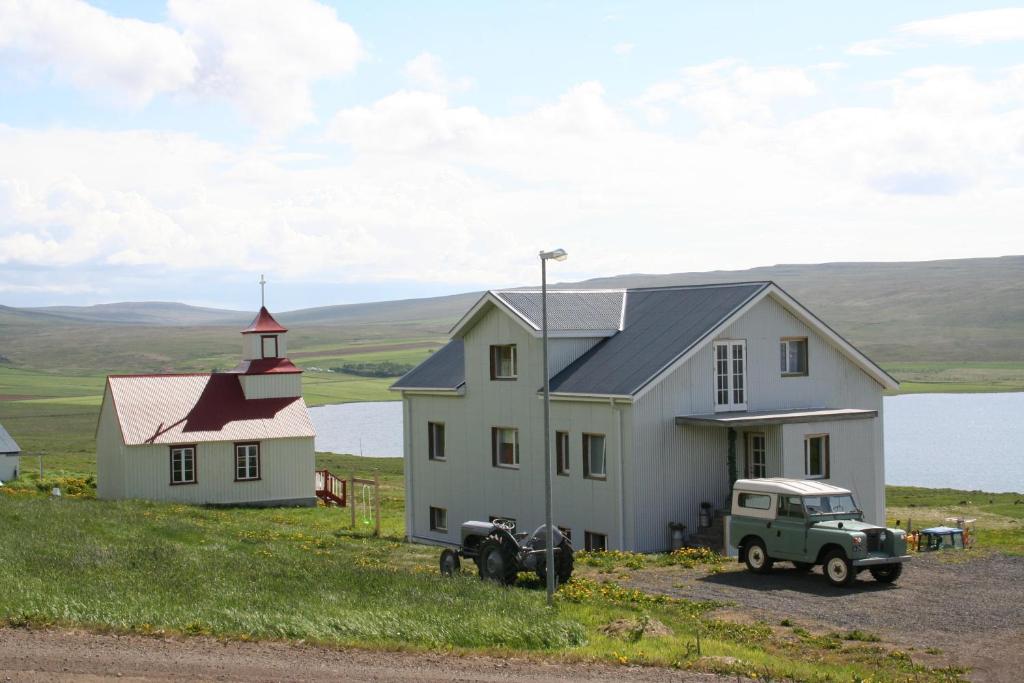 a white truck parked in front of a house at Guesthouse Svinavatn in Svínavatn