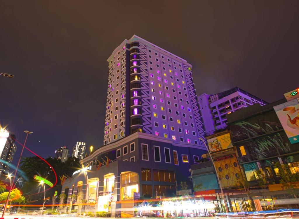 ein großes Gebäude mit lila Lichtern darüber in der Unterkunft AnCasa Hotel Kuala Lumpur, Chinatown by AnCasa Hotels & Resorts in Kuala Lumpur