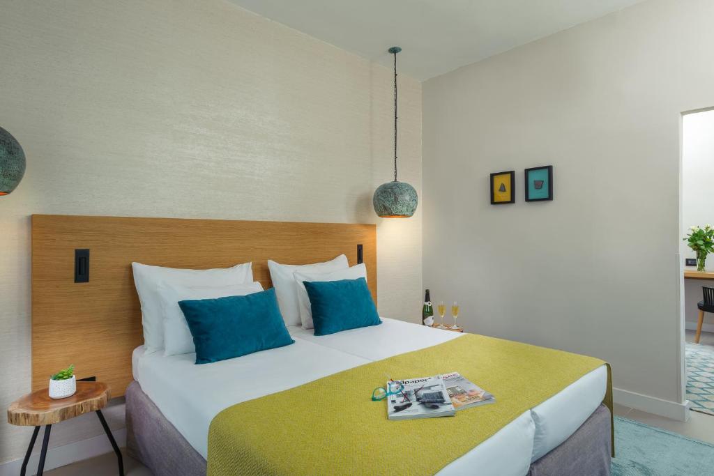 فندق بريما الجليل طبريا في طبرية: غرفة نوم بسرير كبير مع وسائد زرقاء